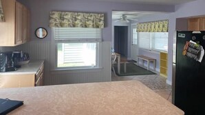A kitchen with a dining area, a ceiling fan, and a refrigerator.