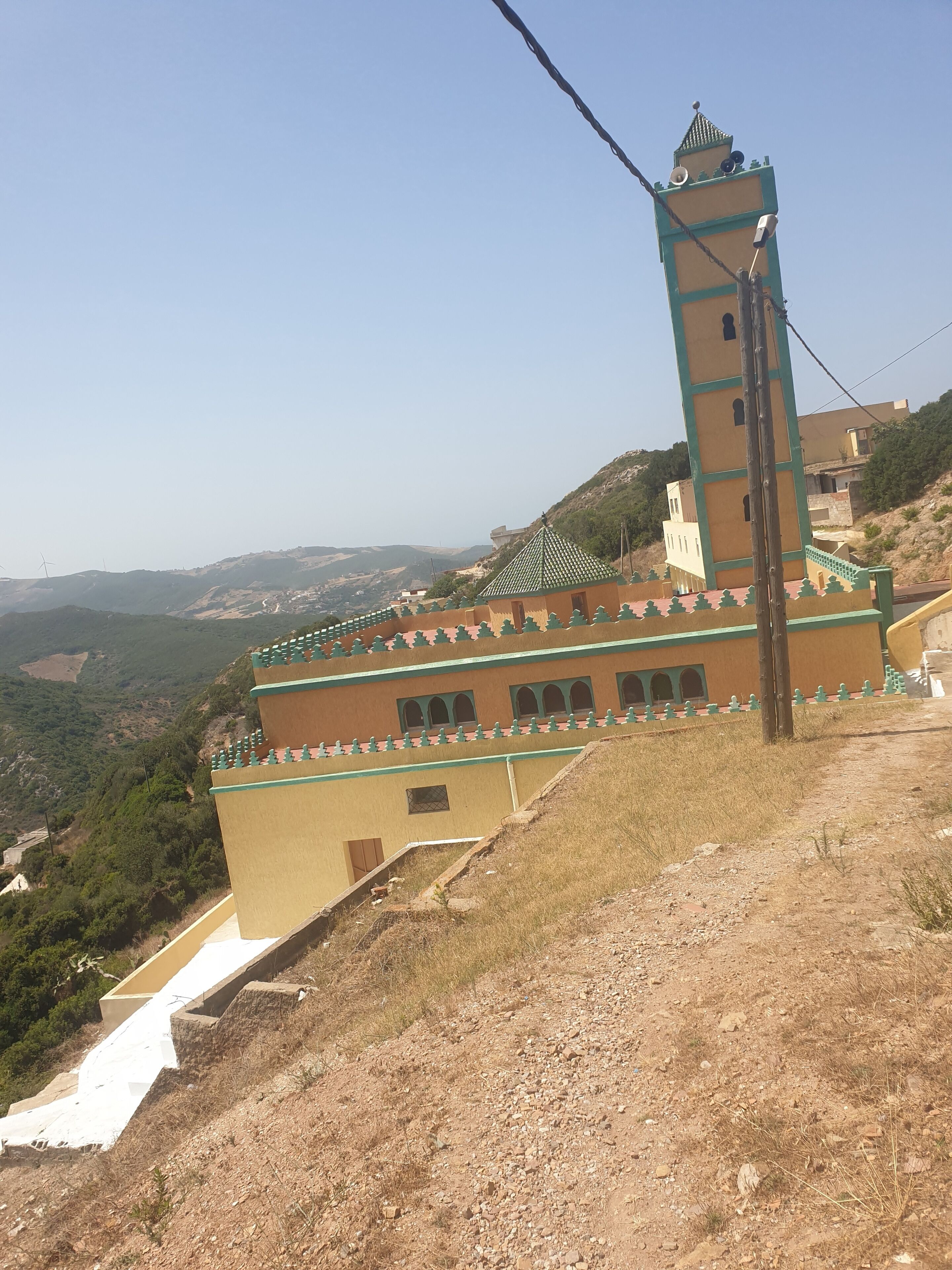 Un bâtiment doté d’une tour, d’un toit en pente et offrant une vue sur une vallée.