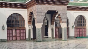 A courtyard with a tiled floor and a building with arches and a green roof. - Apartment Bab Andalous III Tanger (Tanger)