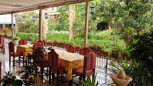An indoor dining area with tables and chairs, surrounded by greenery and a glass barrier. - Apartment Bab Andalous III Tanger (Tanger)
