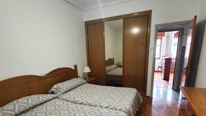 Ein Schlafzimmer mit einem hölzernen Bett, einem Schminktisch und einem Spiegel.