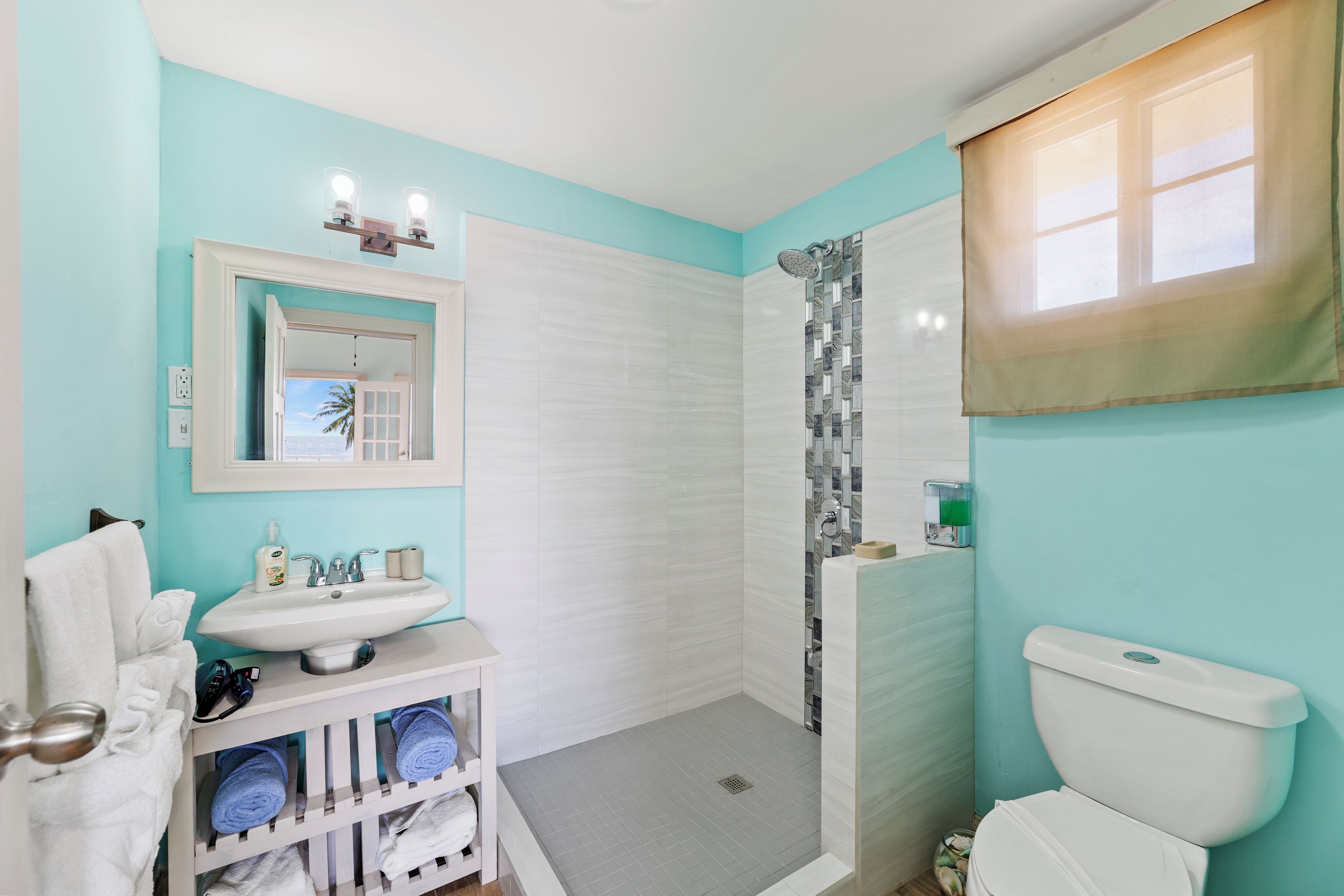 A bathroom with a sink, mirror, and toilet.