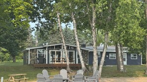 A cabin with a deck and outdoor seating area. - Latitude Adjustment in Elk Rapids (Elk Rapids)