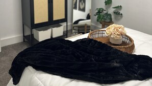 Een slaapkamer met een bed, een kledingkast, een spiegel en een potplant.