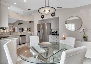 Enjoy cooking in this well-equipped kitchen with a central island, refrigerator, and coffee maker.