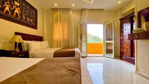 Une chambre d’hôtel avec deux lits, une grande fenêtre avec des rideaux, une tête de lit en bois et un élément décoratif mural.