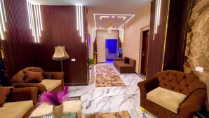 Un hall d'hôtel moderne, doté de sièges confortables, d'un vase décoratif et d'un sol à motifs de marbre.