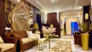 Un salon moderne avec un canapé marron, un tapis à motifs et une lampe décorative.