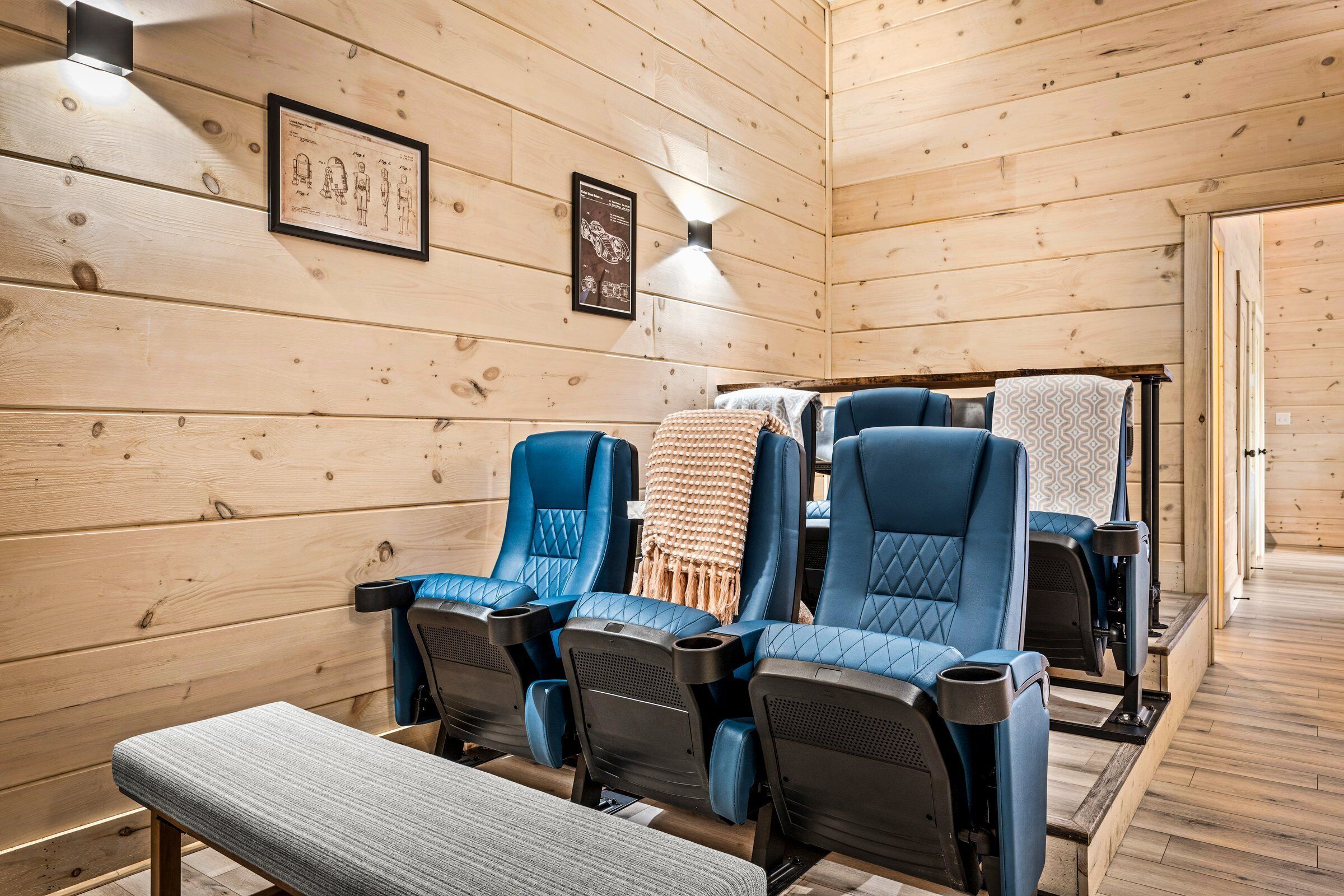 Una sala de sauna con paredes de madera, varias sillas de masaje azules y un banco.