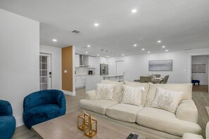 Relax in this spacious living area with a large sofa, armchair, and dining table.