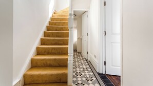 Una escalera con peldaños alfombrados que lleva a una puerta.