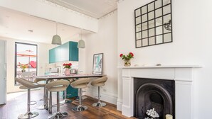 Una cocina moderna con zona de comedor, suelo de madera y chimenea.