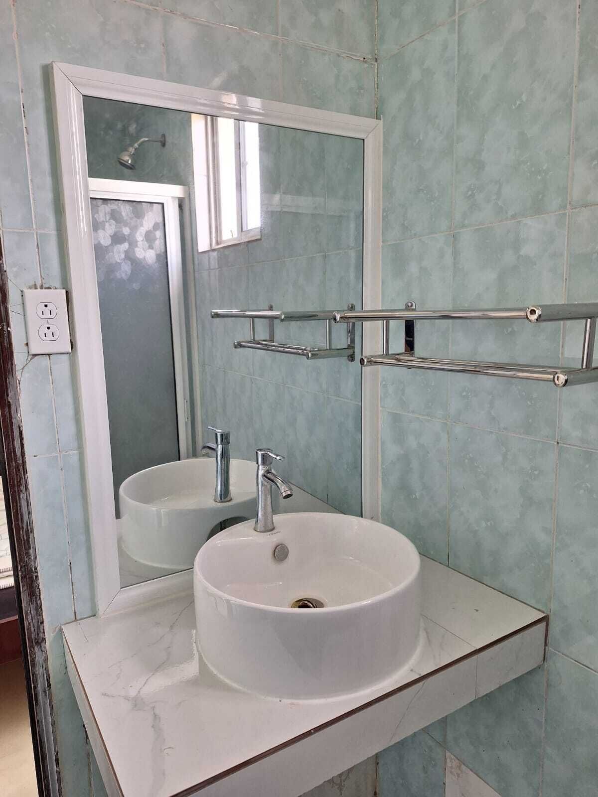 Une salle de bain avec un lavabo blanc, un miroir et une douche.