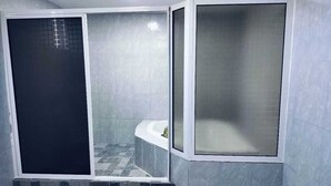 Un bagno con cabina doccia, pareti piastrellate e lavabo.