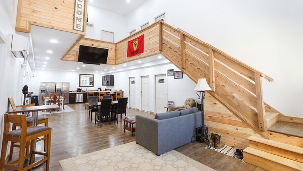 Un vaste espace de vie comprenant un escalier en bois, un coin repas et une cuisine.