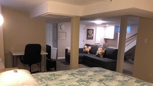 Una habitación de hotel con una cama, un escritorio, una silla, un sofá y una escalera.