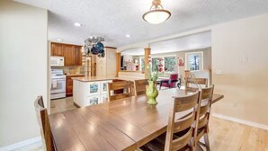 A spacious kitchen with wooden cabinets, a central island, and a dining area with a wooden table and chairs.