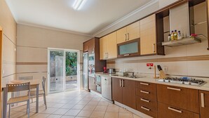 Une cuisine moderne avec des meubles en bois, une cuisinière à gaz et un lave-vaisselle.
