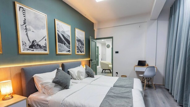 Une chambre d’hôtel moderne avec un grand lit, des tables de chevet, un bureau et une chaise.