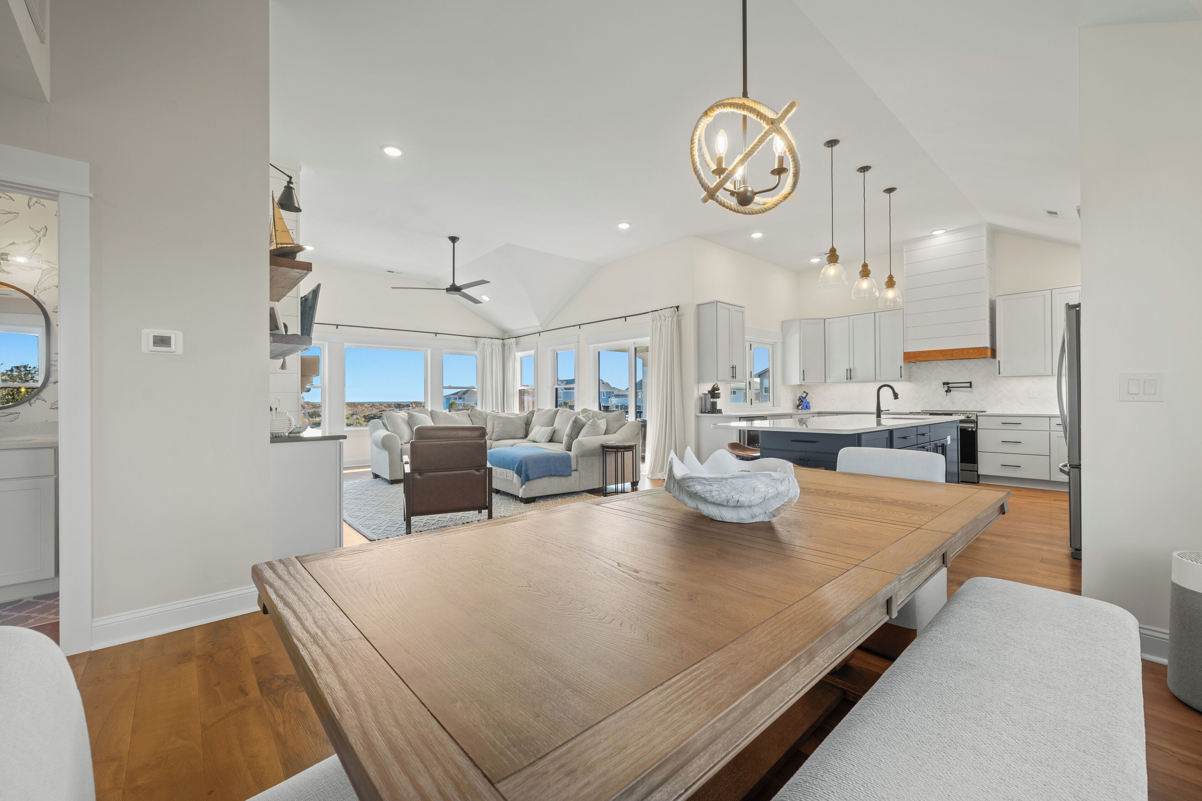 A spacious living area with a wooden dining table, a large window, and a view of the outdoors.
