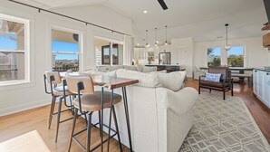 A spacious living area with a sofa, chairs, and a dining table. - Wags & Waves: Sept. 18th Wk Reduced, Fri-Fri, Dog-friendly, Walk to Beach (Corolla)