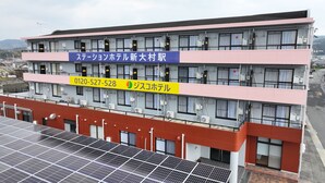 Un immeuble à plusieurs étages, sur lequel on peut lire une enseigne indiquant qu’il s’agit d’un nouvel hôtel situé dans la ville de Saitama.