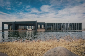 A modern building with large windows, a pool, and a fountain. - Finca Boutique Un Buen Año (Eugenio Bustos)