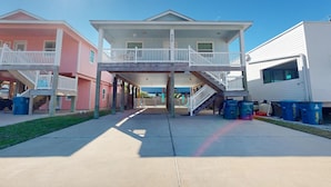 Una hilera de casas de playa con balcones, un corredor cubierto y un cielo despejado.
