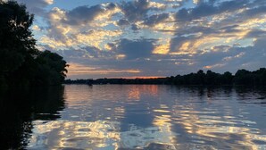 A calm river reflecting the sky with clouds.