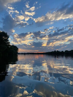 A calm river reflecting the sky with clouds.