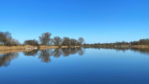 A calm lake with a clear reflection of trees and a boat.