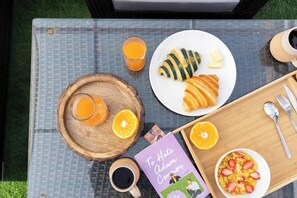 A table with breakfast items including croissants, orange juice, coffee, and a book titled "To Hate Adam Connor". - Modern 2 Bedroom Apartment in Putalisadak, Kathmandu (Kathmandu)