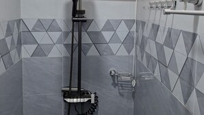 Een moderne badkamer met een douche, betegelde wanden en een raam met een structuurpatroon.