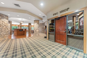 A lobby with a checkered floor, a reception desk, and a pro shop.