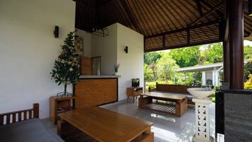 Un espacio de sala de estar moderno y abierto con una mesa de comedor de madera, un sofá y un árbol de Navidad.