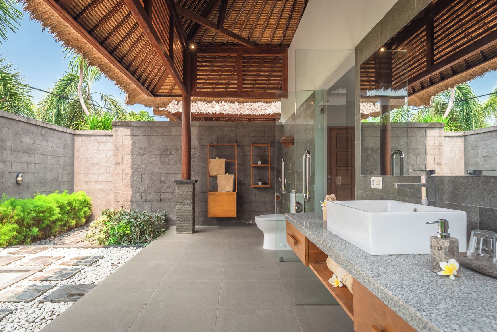 A modern bathroom with a large bathtub, a glass shower enclosure, and a wooden vanity.