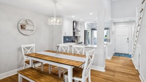 A modern kitchen with white cabinetry, a central island, and a built-in stove.