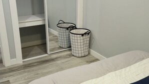 Ein Schlafzimmer mit einem Bett, einem Kleiderschrank und zwei Wäschekörben.