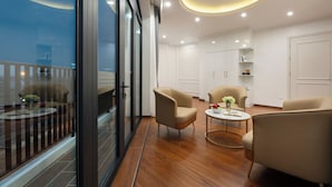 Una habitación de hotel moderna con balcón, piso de madera y muebles contemporáneos.