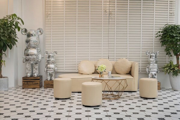 A modern living room with a sofa, ottomans, and decorative bear sculptures.