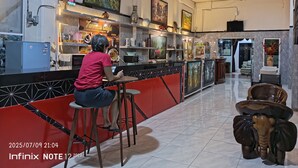 Una moderna hall d'albergo con area bar, opere d'arte alle pareti e un angolo relax caratterizzato da un tavolo a forma di elefante.