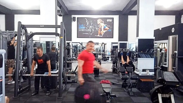 Una palestra con diverse attrezzature per l'allenamento, tra cui macchinari per pesi e pesi liberi.
