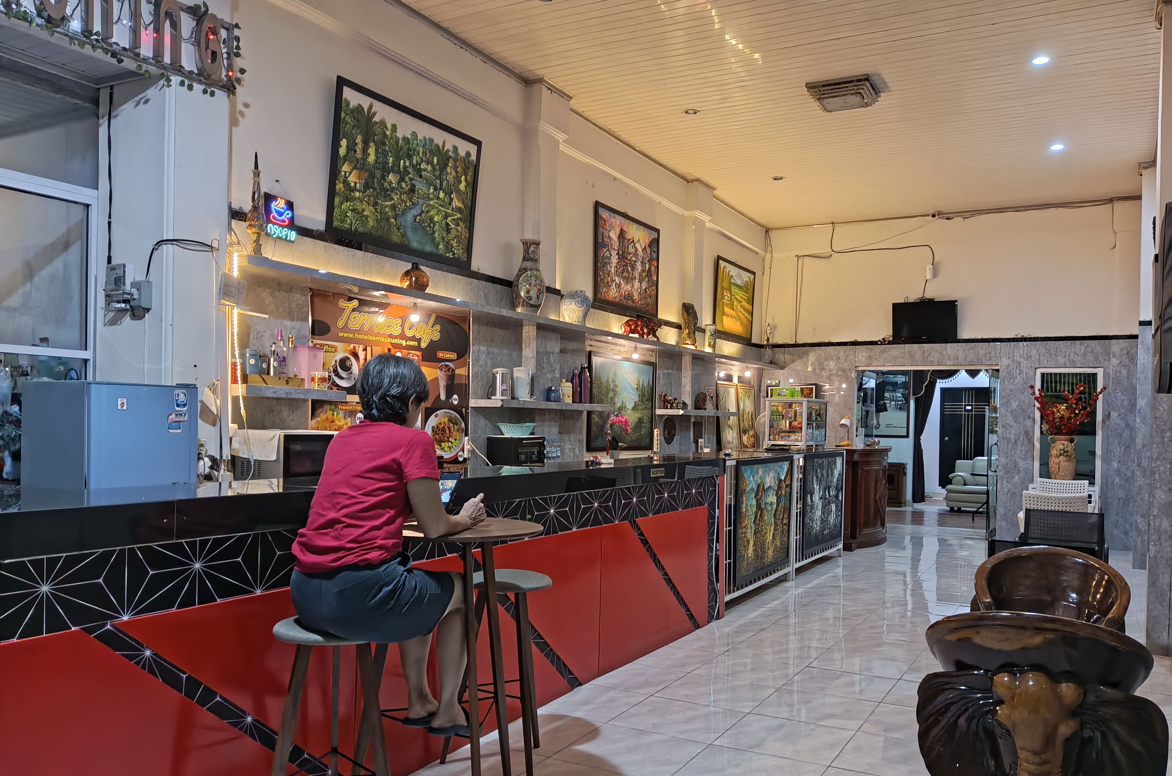 A modern hotel lobby with a bar area, artwork on the walls, and a seating area with a unique elephant-shaped table.