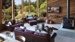 A modern living room with leather sofas, a wooden coffee table, and a fireplace.