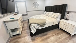 A bedroom with a bed, bedside table, dresser, and a wall-mounted TV. - Spacious 4-bedroom house with Hot Tub in beautiful Balch Springs with AC, WiFi (Balch Springs)