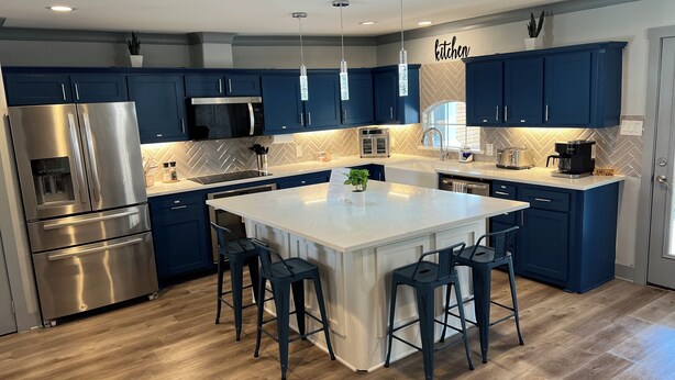 A modern kitchen with dark blue cabinets, stainless steel appliances, and a central island with bar stools. - Spacious 4-bedroom house with Hot Tub in beautiful Balch Springs with AC, WiFi (Balch Springs)
