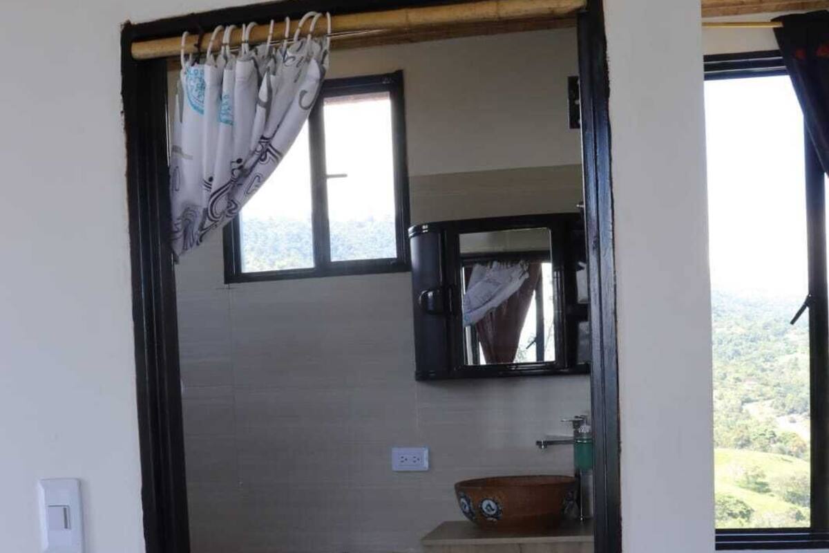 Ein kleines, kompaktes Badezimmer mit Toilette, Waschbecken und Spiegel.