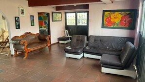 A spacious living area with a wooden sofa, a modern sectional sofa, and a dining table. - Finca Recreativa los Altos Giraldos (Arbeláez)