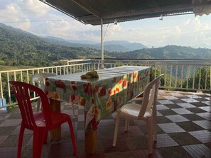 Une table recouverte d’une nappe, deux chaises et une banane posée sur la table.