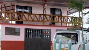 A building with a checkered floor, a gated entrance, and a parked car. - Finca Recreativa los Altos Giraldos (Arbeláez)